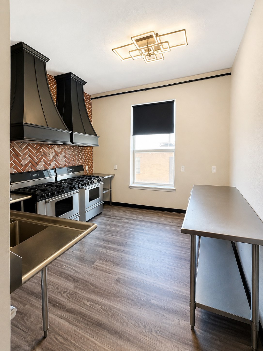 Shared commercial kitchen with stainless ranges and herringbone tile